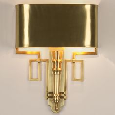 a wall light with a black shade on the top and gold trim around the bottom