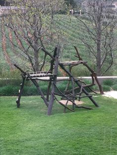 a wooden structure sitting in the middle of a lush green field