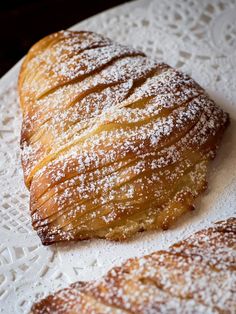 two croissants sitting on top of a white doily