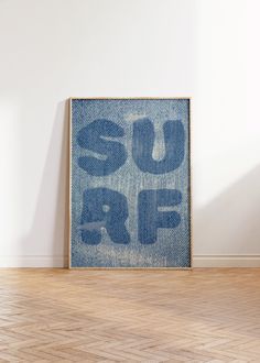 a blue sign that says suff on it in front of a white wall and wooden floor