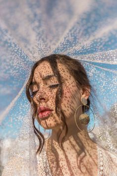 a woman with freckles on her face is holding an umbrella