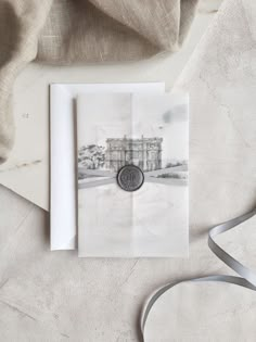 a white card with a black and white photo on it next to a silver ribbon