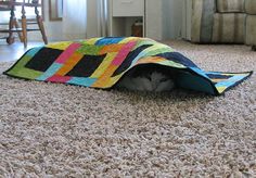 a cat is hiding in a bag on the floor with it's eyes closed