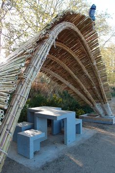 a bamboo structure with benches under it