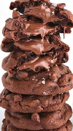 chocolate cookies stacked on top of each other with melted chocolate in the middle and frosting between them