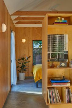 a bedroom with wooden walls and shelves filled with books