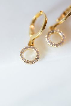 Our Myla Dainty O-Ring Huggie Earrings are the perfect minimalist earrings! Made with a crystal beaded gold filled O-Ring attached to a gold filled huggie hoop. These simple earrings are a beautiful staple piece! Everyday Cubic Zirconia Jewelry With Halo, Everyday Cubic Zirconia Halo Jewelry, Gold Dangle Hoop Earrings With Halo Design, Gold Drop Earrings With Halo Design, Gold Dangle Jewelry With Halo Design, Everyday Gold Crystal Earrings, Minimalist Gold Jewelry With Halo Design, Gold Halo Design Dangle Jewelry, Gold Halo Design Diamond Drop Earrings