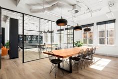 an empty conference room with large windows and lots of chairs around the table in front of it