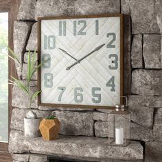 a large clock mounted to the side of a stone wall next to a fire place