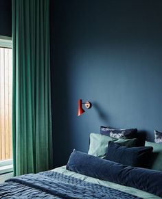 a bedroom with blue walls and green curtains