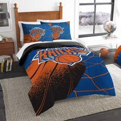 a bed with an orange and blue basketball on it