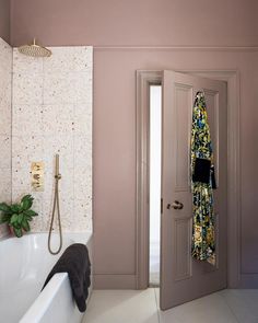 an open door leading to a bathroom with a bathtub and shower head in it