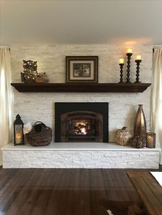 a living room with a fire place and some candles on the fireplace mantels