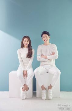 two people sitting on top of white stools