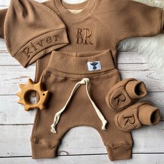 a brown sweater and pants with the words river rr written on it, along with two wooden teeth