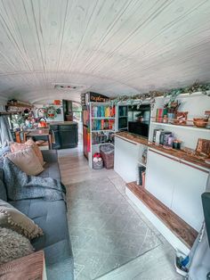 a living room filled with furniture and bookshelves next to a kitchen counter top