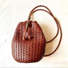 a brown woven purse sitting on top of a white table