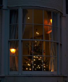 a christmas tree is lit up in the window