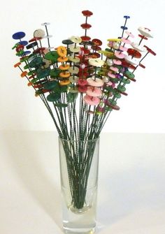 a vase filled with lots of different colored pins