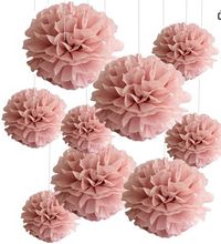 six pink tissue pom poms hanging from strings