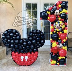 a mickey mouse balloon sculpture in front of a house with the number 1 on it