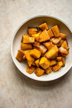 a white bowl filled with cooked sweet potatoes