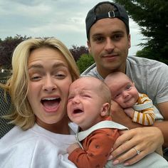 a man and woman holding two babys while posing for a picture with their mouths open