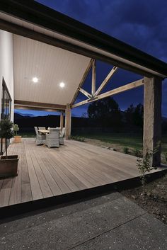 an outdoor deck at night with chairs and table