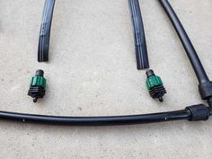 four black and green hoses laying on the ground next to each other, with one attached