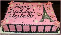 a pink birthday cake with the eiffel tower on it's side and hearts