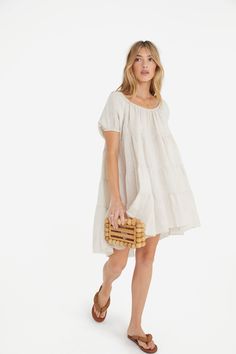 This flirty dress is reimagined with a linen slub. The scoop neck is framed by puffed sleeves with encased elastic openings. The bodice to bottom is covered with gathered layers giving this dress a flirty look. 100% linen Care instructions: hand wash. Bust: 48” Waist: 76” Length: 32” Made in Italy. Spring Beige Tiered Dress With Ruffle Hem, Beige Tiered Dress For Brunch, Chic Beige Tiered Dress With Ruffles, Beige Ruffle Hem Midi Dress For Day Out, Beige Midi Dress With Ruffle Hem For Day Out, Casual Beige Tiered Dress With Ruffle Hem, Cream Tiered Summer Dress, Beige Tiered Midi Dress For Brunch, Beige Tiered Dress With Ruffle Hem