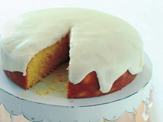 a cake with white frosting is on a plate and has one slice cut out