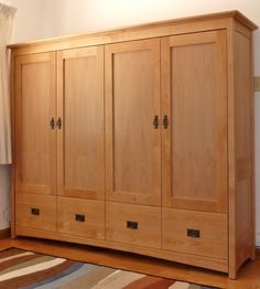 a large wooden armoire sitting on top of a rug in a living room next to a window