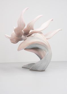 a sculpture is shown with white and pink shapes on the top, and bottom part of it's body