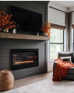 a living room with a couch, fireplace and large windows in it's center