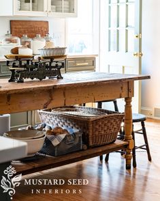 a kitchen island with baskets on it in front of an open door that leads to a breakfast nook