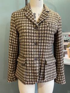 Gorgeous Tweed Riding Jacket in 100% wool with leather under collar and packet flaps Large Houndstooth pattern in brown on beige ground Riding jacket back belted detail and vent Bellows pockets and metal shank buttons Cool pinstriped lining Immaculate condition as hardly worn and a very flattering fit Brown Wool Sport Coat With Lapel Collar, Fall Sport Coat With Houndstooth Pattern And Suit Collar, Brown Wool Sport Coat, Brown Buttoned Sport Coat For Fall, Brown Sport Coat With Buttons For Fall, Brown Tweed Sport Coat For Office, Brown Herringbone Sport Coat For Workwear, Brown Herringbone Sport Coat For Work, Tailored Tweed Jacket With Flap Pockets For Fall