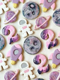 decorated cookies with space themed icing on a table