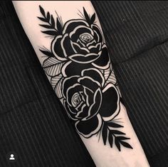 a black and white rose tattoo on the arm