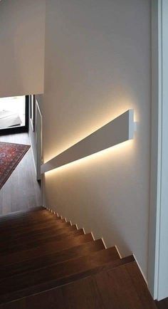 the light on the wall shines brightly in the hallway, which is next to stairs