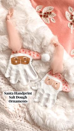 two handmade mittens and gloves are laying on a white fur covered blanket,