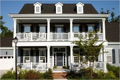 a large white two story house with balconies on the front and second story