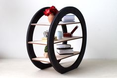 a circular shelf with books and vases on it