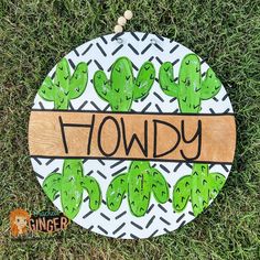 a wooden sign that says plowdy with green cactuses and the word plowdy on it