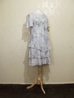 This is a very pretty 2 piece sleeveless long layered dress with matching long sheer chiffon jacket by r&m richards. still in brand new condition. it is a size 8. please go by the measurements below for proper fit. very elegant pretty women look. perfect for a garden party or summer wedding. the dress has a modest scoop neckline with a small keyhole button back. the dress is made of a pastel light sage green floral print crepe chiffon. the flowers are very light pastels of pinks and periwink Summer A-line Dress For Mother Of The Bride, Spring A-line Dress For Mother Of The Bride, Spring Short Sleeve Dress With Overlay, Spring Dress With Short Sleeves And Overlay, Spring Dresses With Overlay And Short Sleeves, Fitted Summer Dress With Overlay, Spring Knee-length Dress For Mother Of The Bride, Knee-length Spring Dress For Mother Of The Bride, Summer Flowy Dress For Mother Of The Bride