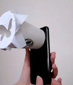 a person holding a cell phone with a paper flower on it