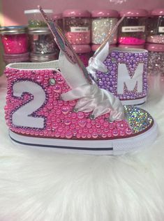 "Add Some Sparkle To Your Kids Birthday, Photo Shoot and Any Other Social Event With These Authentic Custom Bling High Top All Star Converse. These Converse Are Hand Painted Pink/Lavender And Encrusted In High Quality Glass Crystals And Peals.  PLEASE DOUBLE CHECK THAT ALL SIZES AND SPELLING PROVIDED IS CORRECT.  Interested In A Different Color? No Worries. Simply Contact Us With The Colors Of Your Choice And We'll Be More Than Happy To Assist You. SIZES: Sneakers Are in U.S Sizes. PLEASE NOTE Converse Runs 1/2 Size Big. Make Sure Your Size Is Correct Before Purchasing. If Your Size Is Not Listed Please Contact Us For Further Assistance. SHIPPING AND PROCESSING TIME: Each Pair Of Sneakers Are Made To Order So Please Allow A 3-4 Week Turnaround Time.  If You Need Your Order Sooner Please Ad Bedazzled Converse, Diy Converse, Diy Glitter Shoes, Rhinestone Converse, Bedazzled Shoes Diy, White Chuck Taylors, Bedazzled Shoes, Purple Converse, Bling Converse