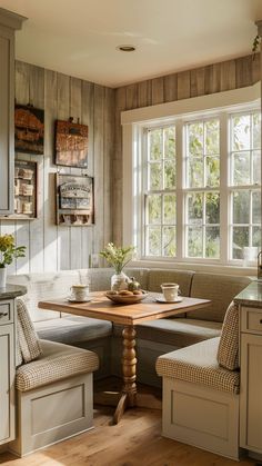 a kitchen with a table and bench in the corner next to two windows that have wood paneling on them