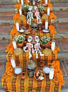 a table topped with lots of decorations and flowers on top of a stair case filled with candles