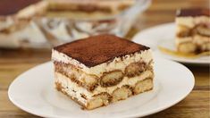 a piece of cake sitting on top of a white plate next to a glass dish